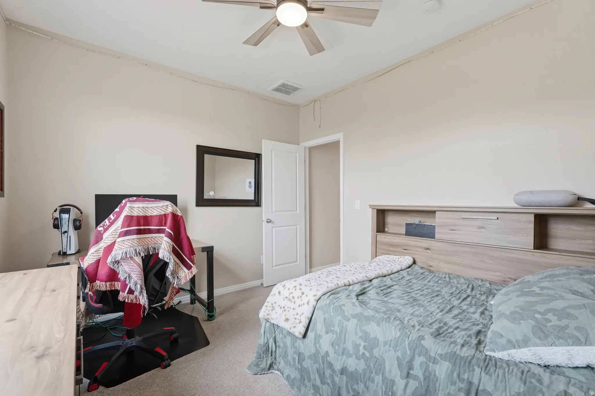 Bedroom featuring light colored carpet and a ceiling fan