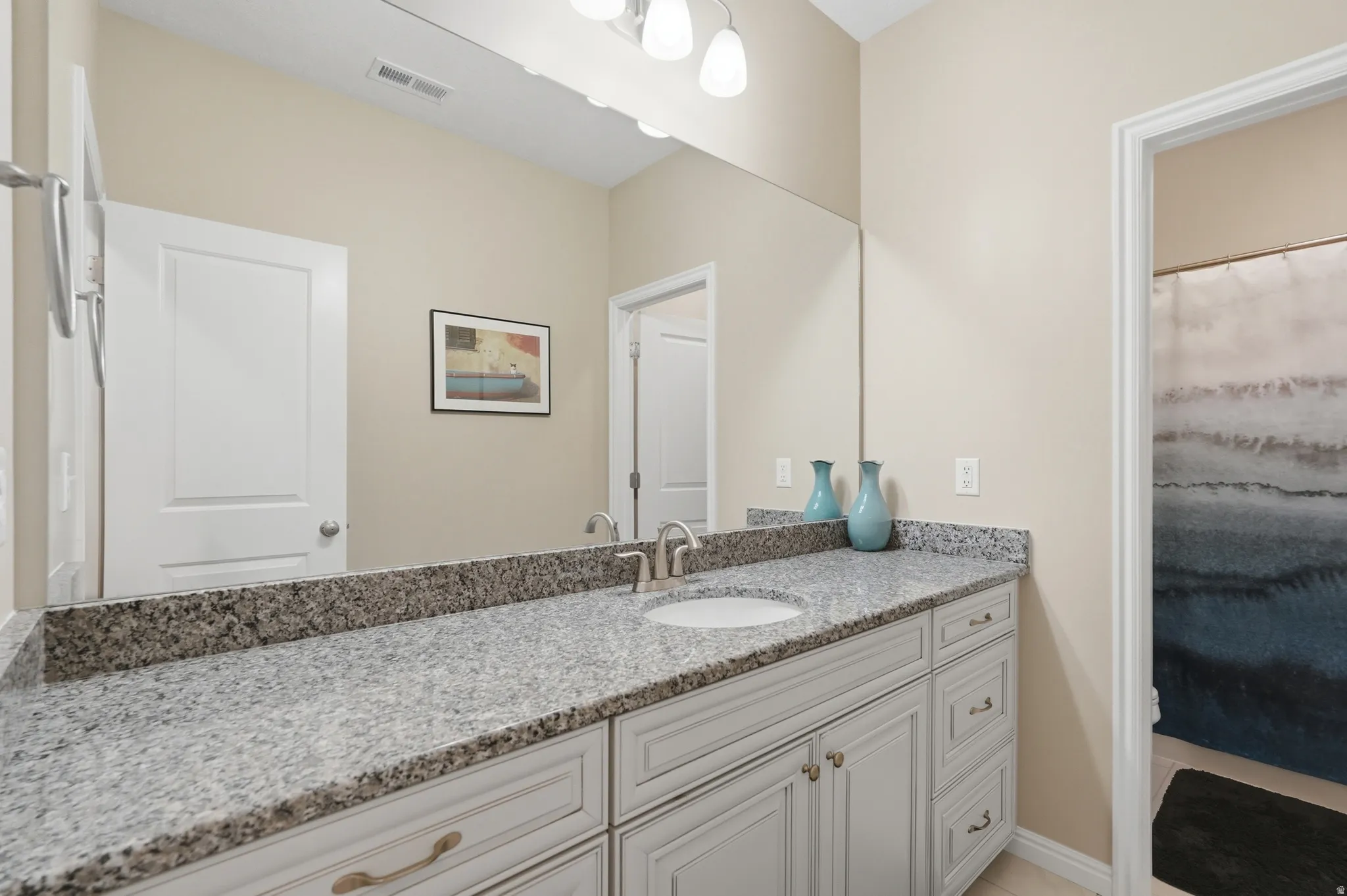 Full bathroom with vanity and a shower with shower curtain