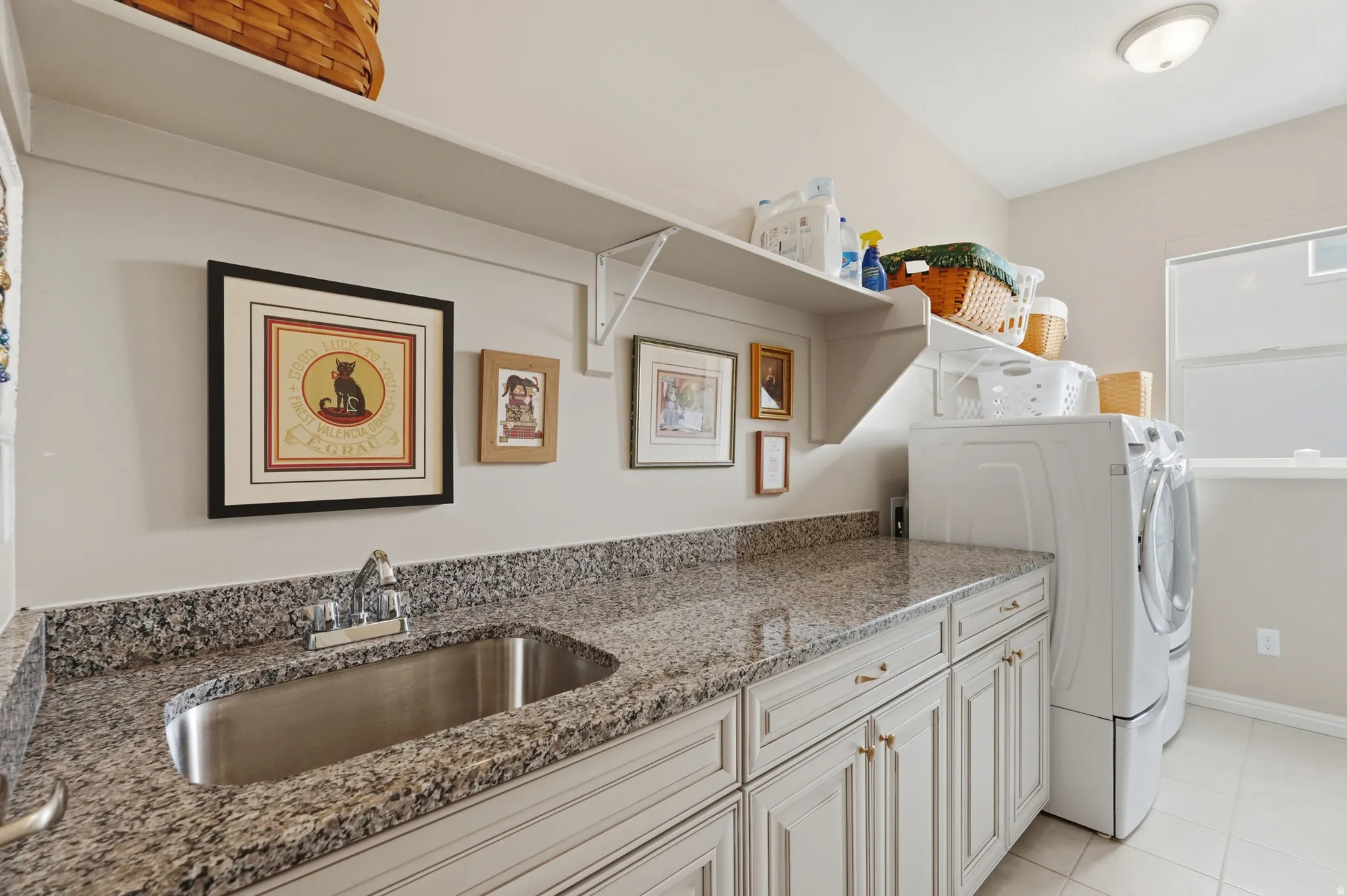 Laundry area featuring cabinet space, washer and dryer, and light tile patterned floors
