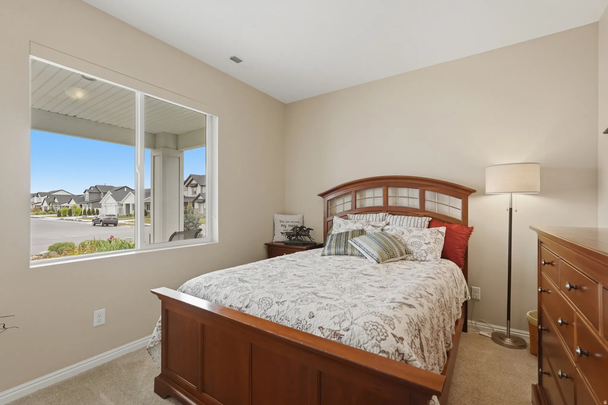 Bedroom featuring a residential view and light carpet