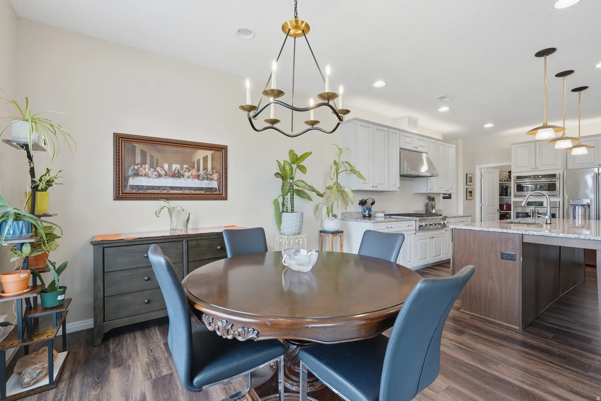 Dining space with suspended lighting and dark wood-type flooring