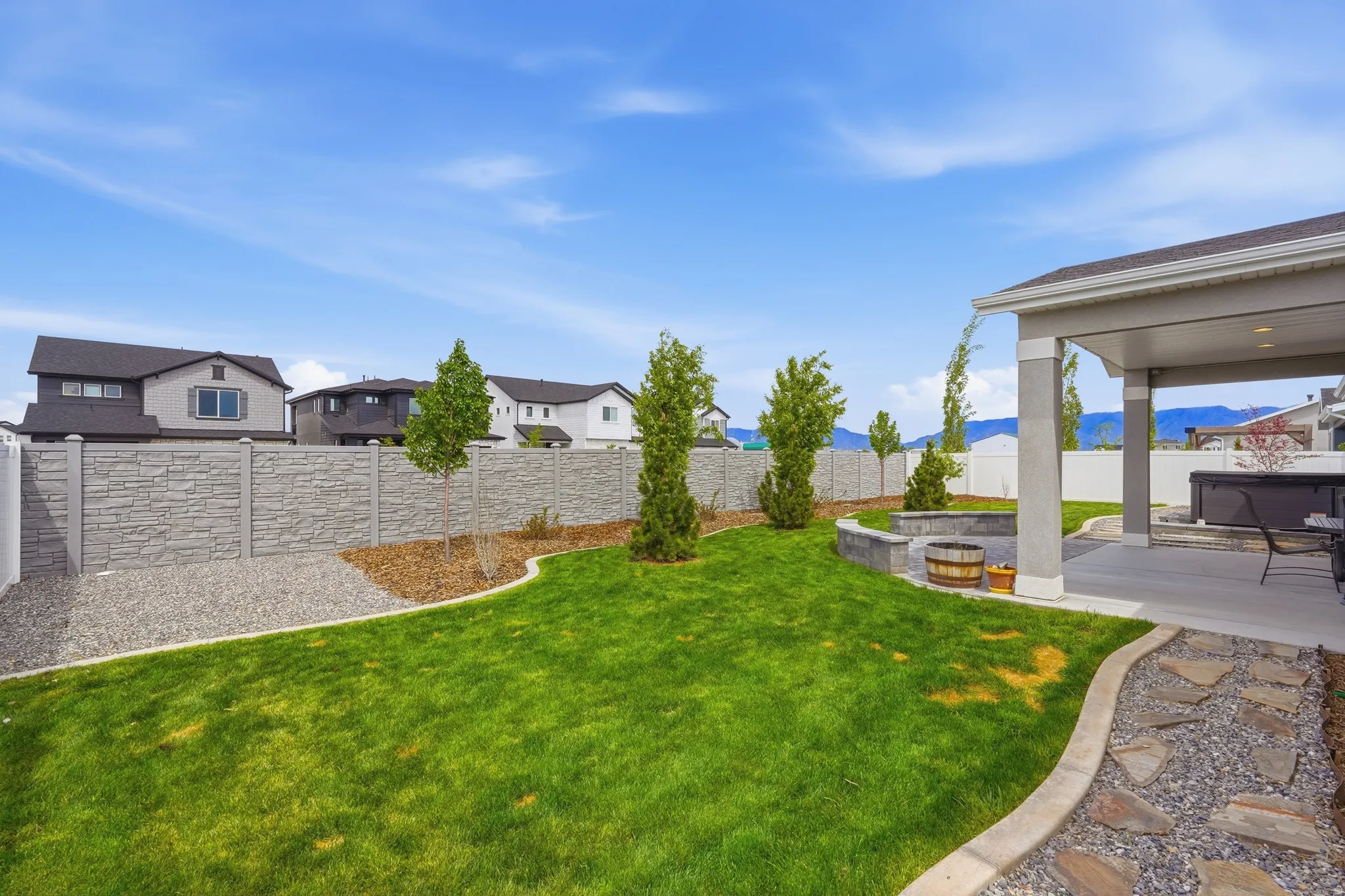 Fenced backyard featuring a patio area, a residential view, and a mountain view