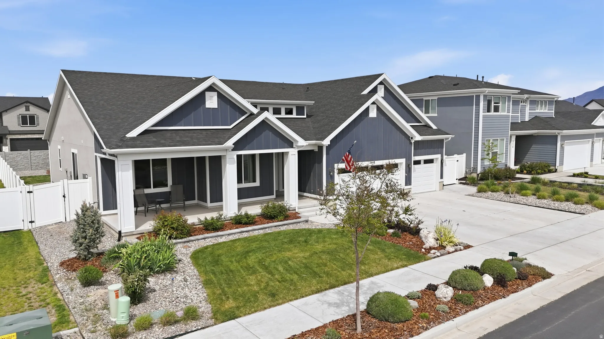 View of front of property with a porch, a gate, concrete driveway, and a shingled roof