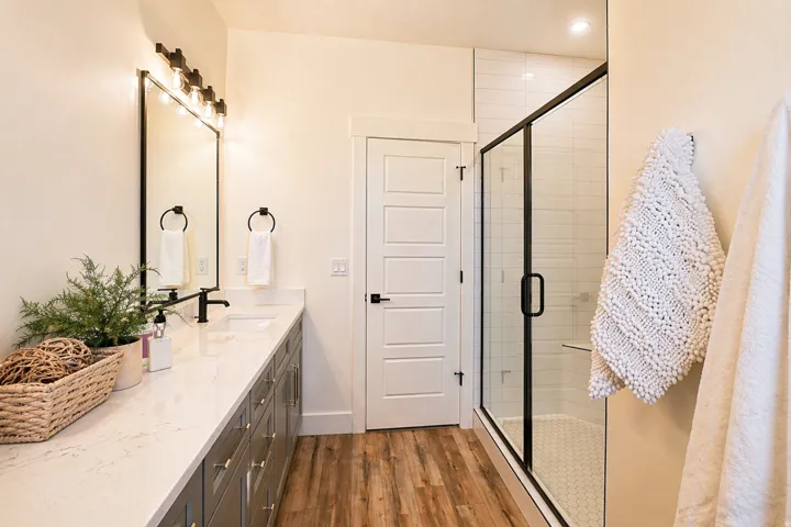 Full bathroom with a shower stall, vanity, and dark wood finished floors