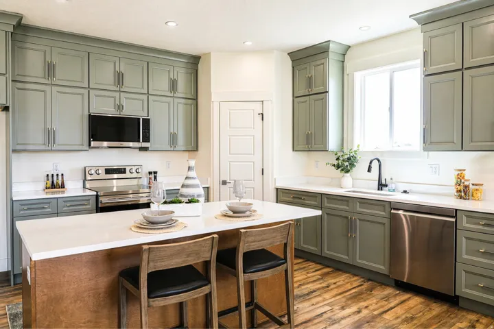 Kitchen featuring stainless steel appliances, a breakfast bar, light stone countertops, dark wood-style flooring, and a center island