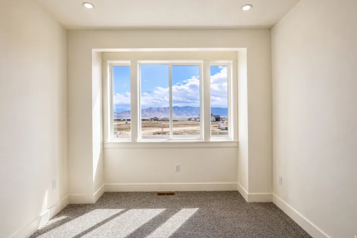 Empty room with a mountain view, carpet, and recessed lighting