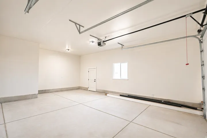 Garage with baseboards and a garage door opener