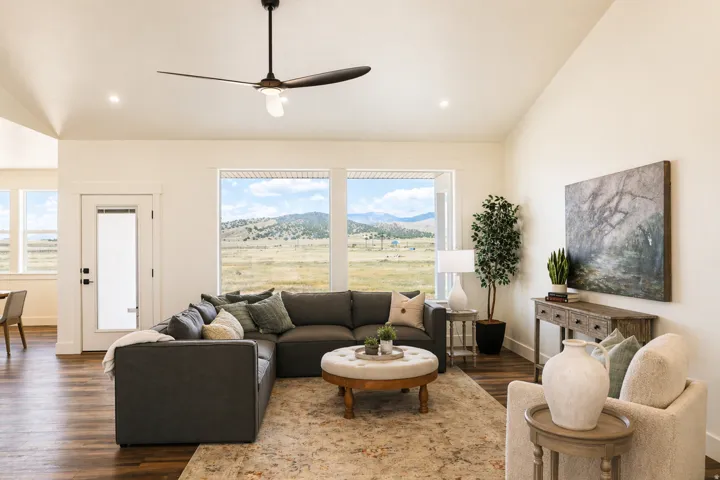 Living area with vaulted ceiling, ceiling fan, a mountain view, and dark wood-style floors