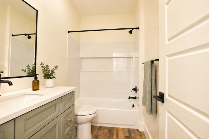 Bathroom featuring vanity, dark wood-type flooring, and bathtub / shower combination