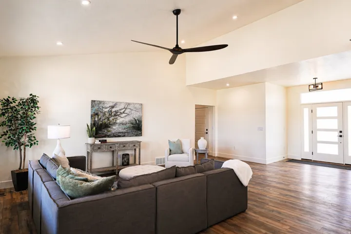 Living area with dark wood-type flooring, ceiling fan, recessed lighting, and vaulted ceiling