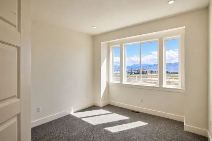 Empty room featuring a mountain view, carpet, and recessed lighting