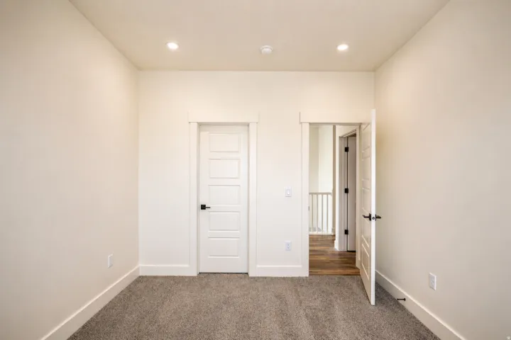 Unfurnished bedroom with dark colored carpet and recessed lighting