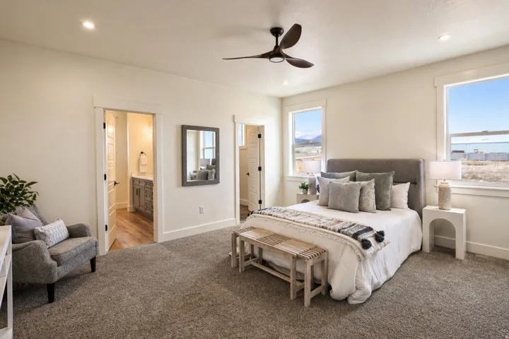 Carpeted bedroom featuring connected bathroom, ceiling fan, and recessed lighting