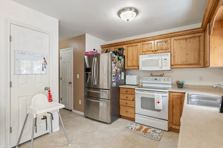 Kitchen with white appliances, light countertops, and light tile patterned flooring