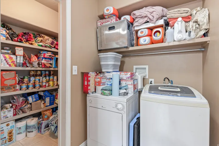 Laundry room featuring independent washer and dryer and light tile patterned floors