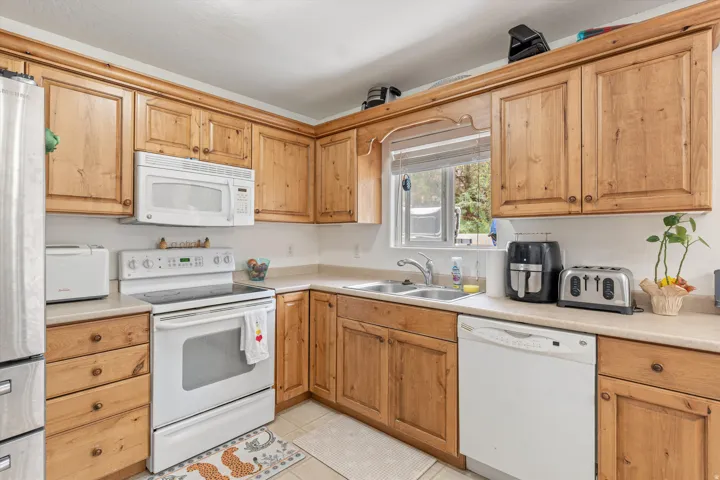 Kitchen with white appliances, light countertops, and light tile patterned flooring