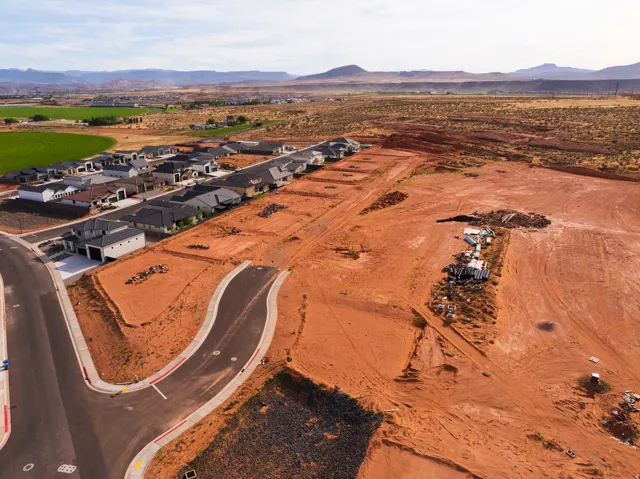Aerial view of sparsely populated area featuring a mountainous background and nearby suburban area