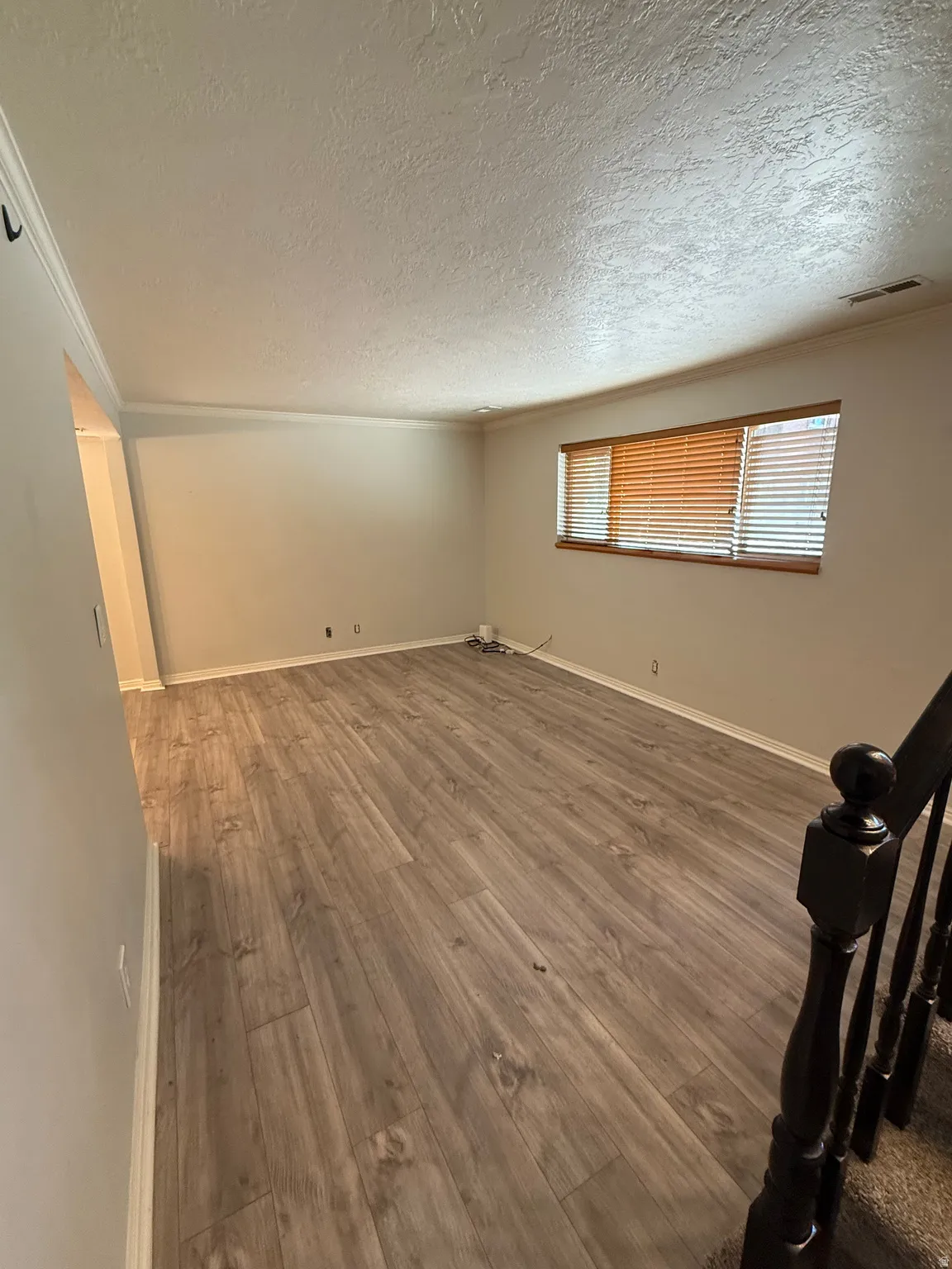Unfurnished room featuring dark wood-type flooring and a textured ceiling