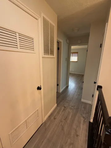 Hall featuring dark wood-type flooring and a textured ceiling