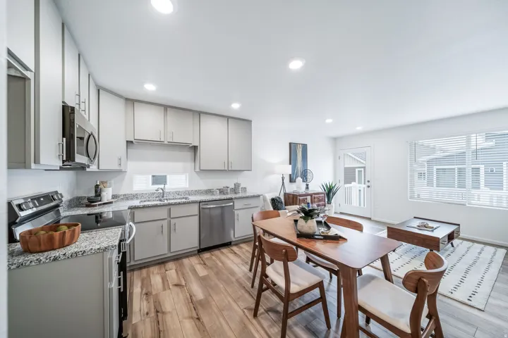 Kitchen with stainless steel appliances, light wood finished floors, light stone countertops, gray cabinetry, and recessed lighting