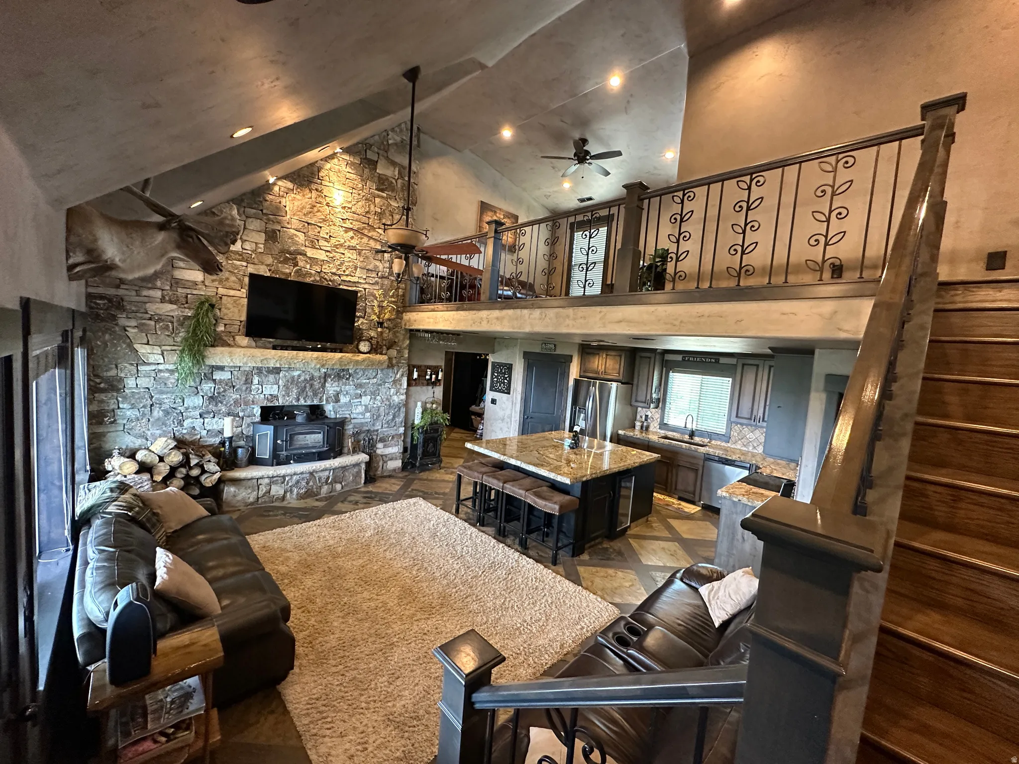 Living room featuring a ceiling fan, vaulted ceiling, and a fireplace