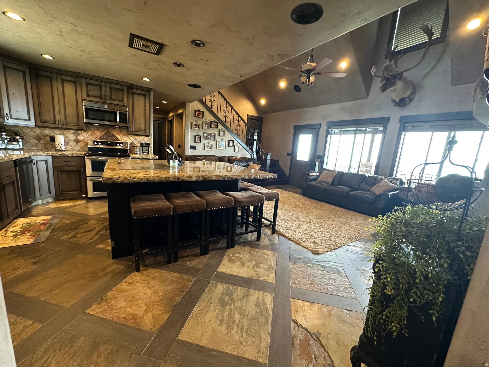 Kitchen with open floor plan, light stone countertops, a center island,  stainless steel appliances
