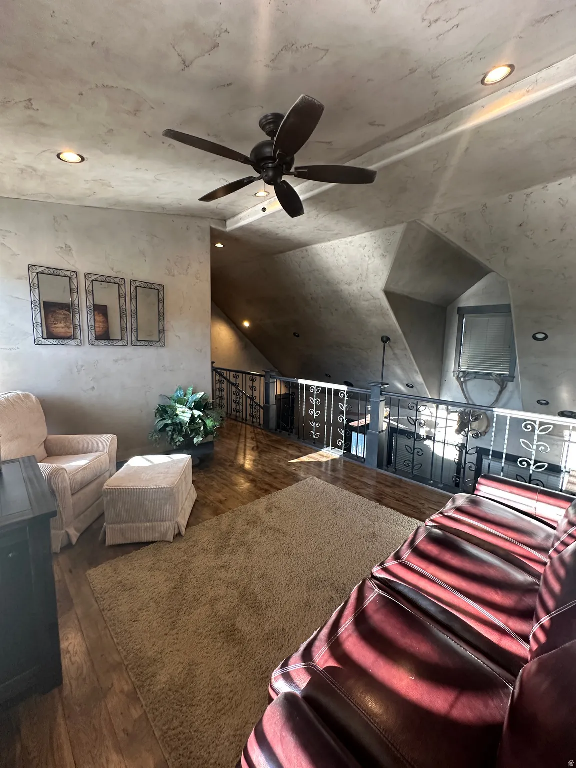 Loft living area featuring dark wood-style flooring, a ceiling fan, recessed lighting, and vaulted ceiling