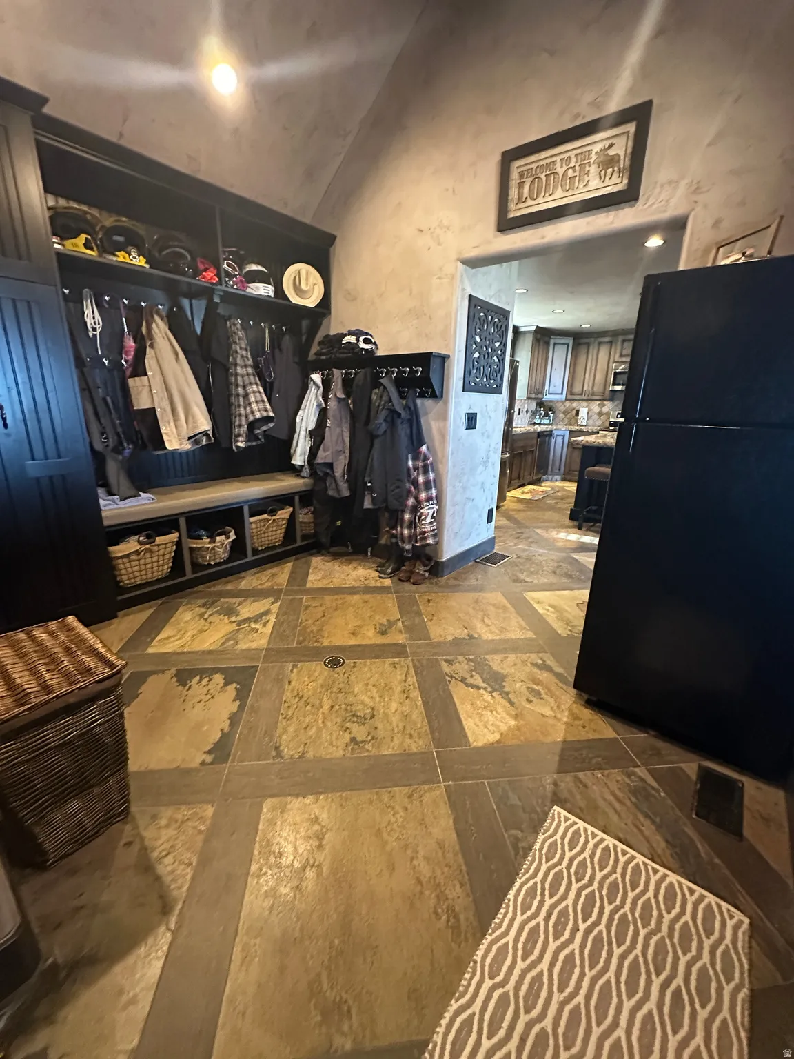 Mudroom featuring vaulted ceiling and baseboards