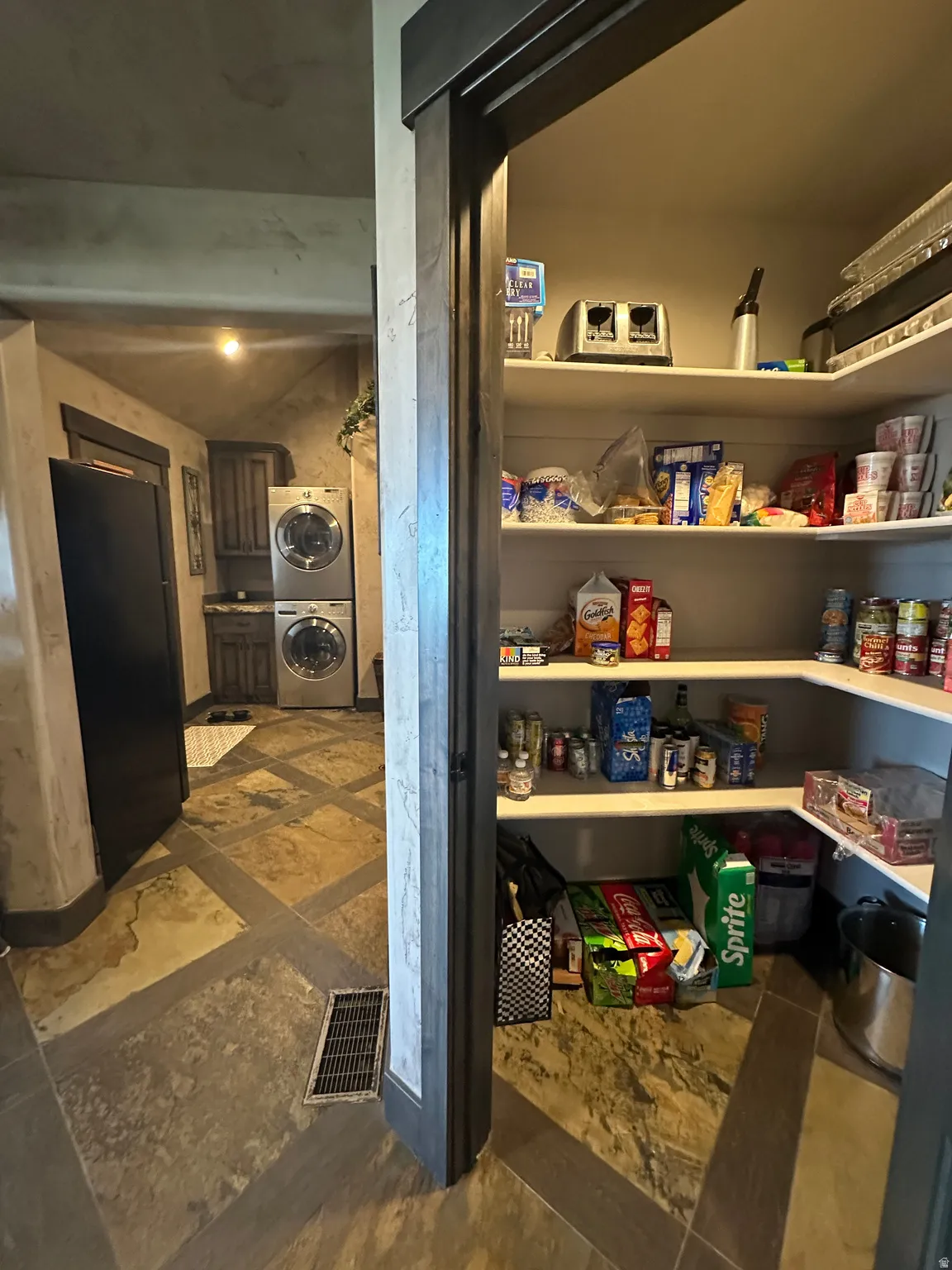 Pantry featuring stacked washer and dryer