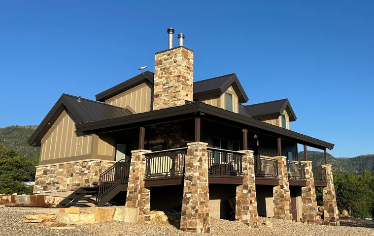 View of property exterior featuring a large porch, stone siding, a chimney, a metal roof, and a mountain view