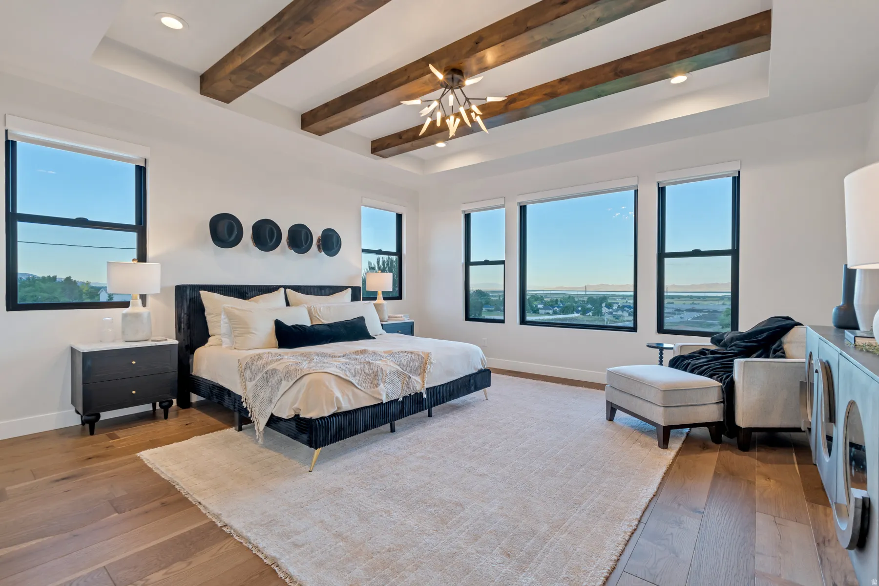 Bedroom featuring beamed ceiling, a raised ceiling, recessed lighting, and hardwood / wood-style flooring
