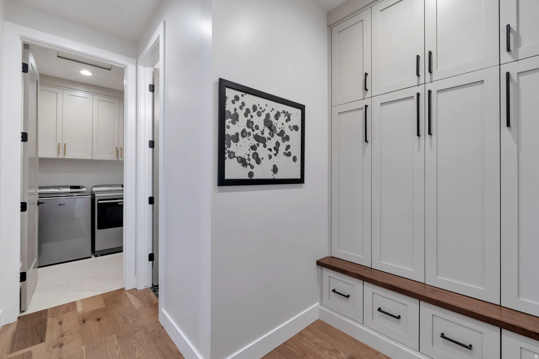 Mudroom featuring light wood-style floors, independent washer and dryer, and recessed lighting