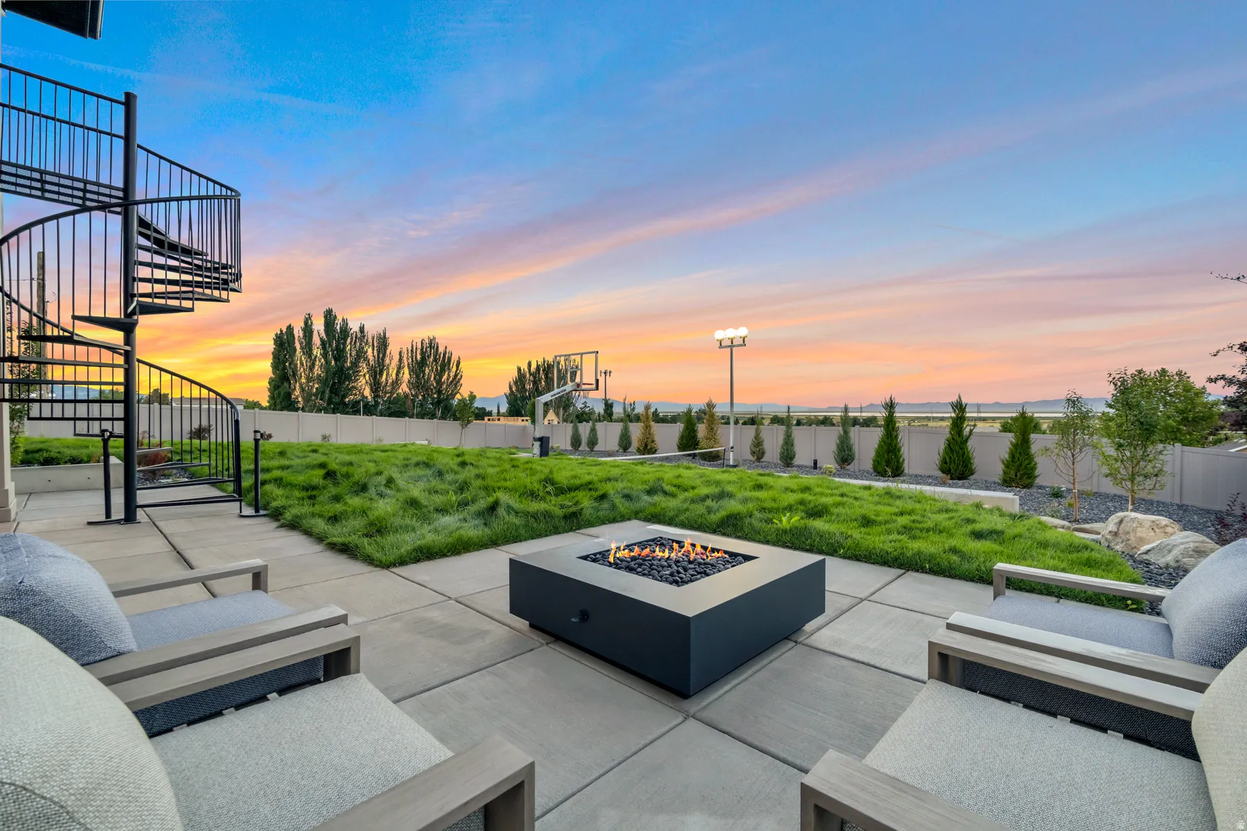 Fenced backyard with stairs and an outdoor living space with a fire pit