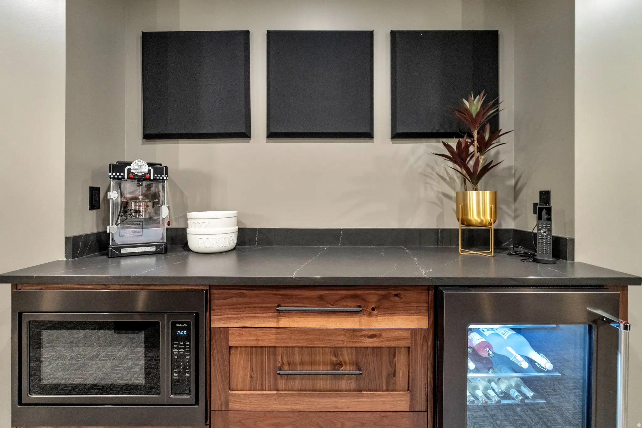Bar with beverage cooler, stainless steel microwave, dark stone counters, and wood finish cabinetry