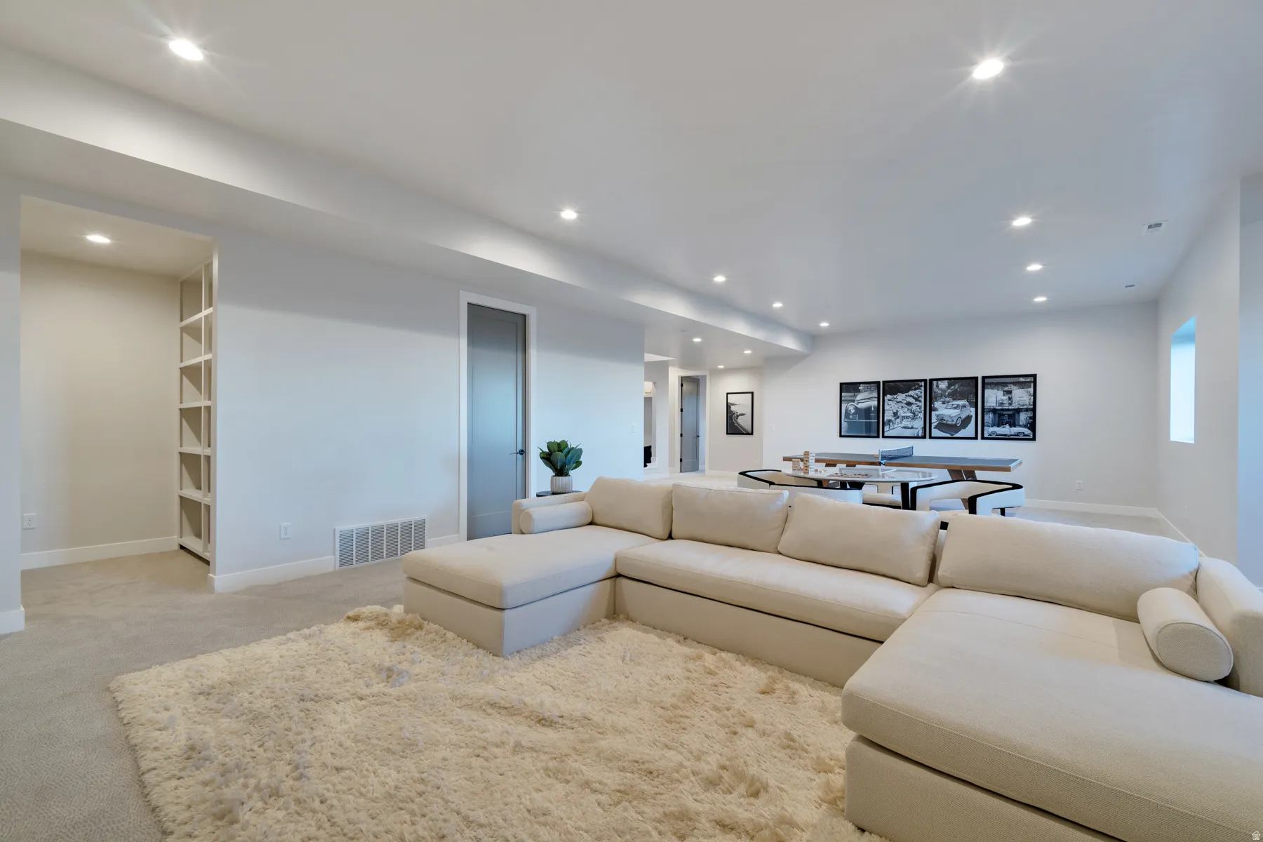 Living area with light colored carpet and recessed lighting