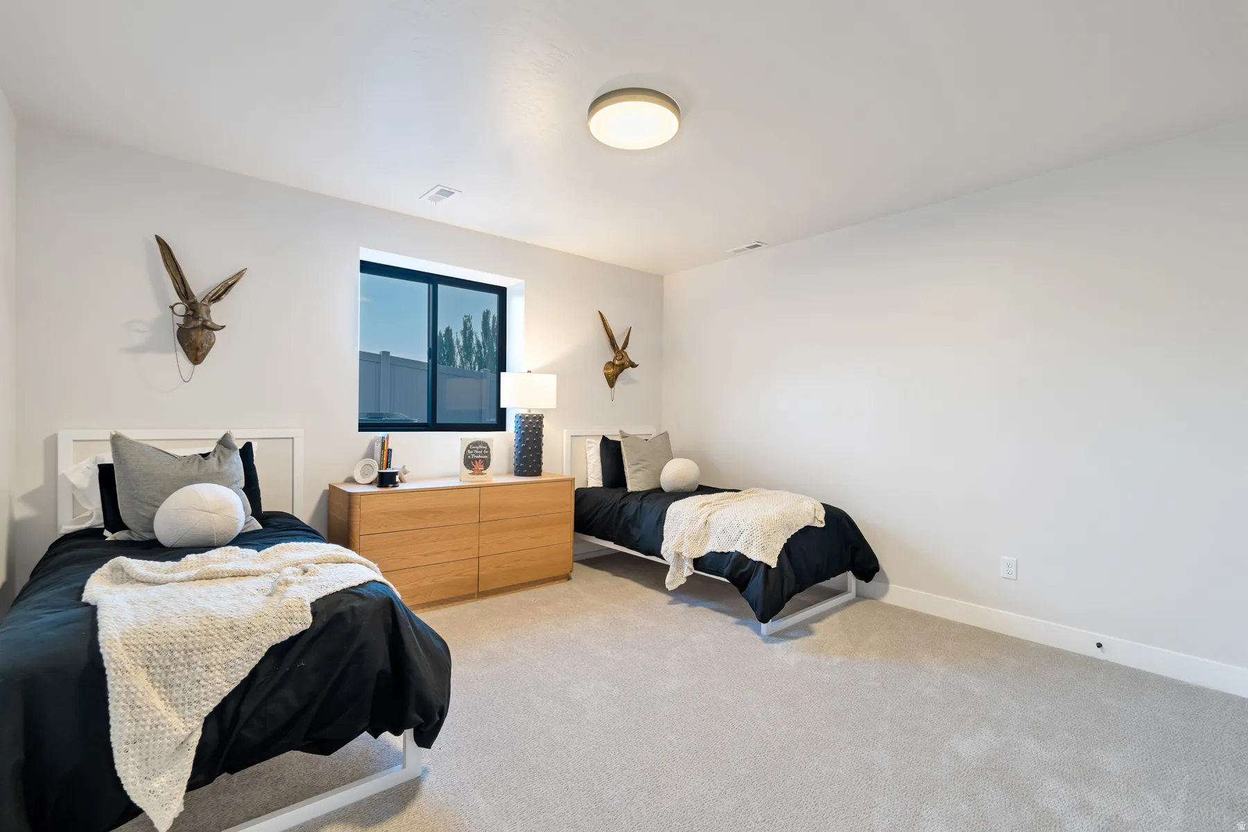 Bedroom with light colored carpet and baseboards