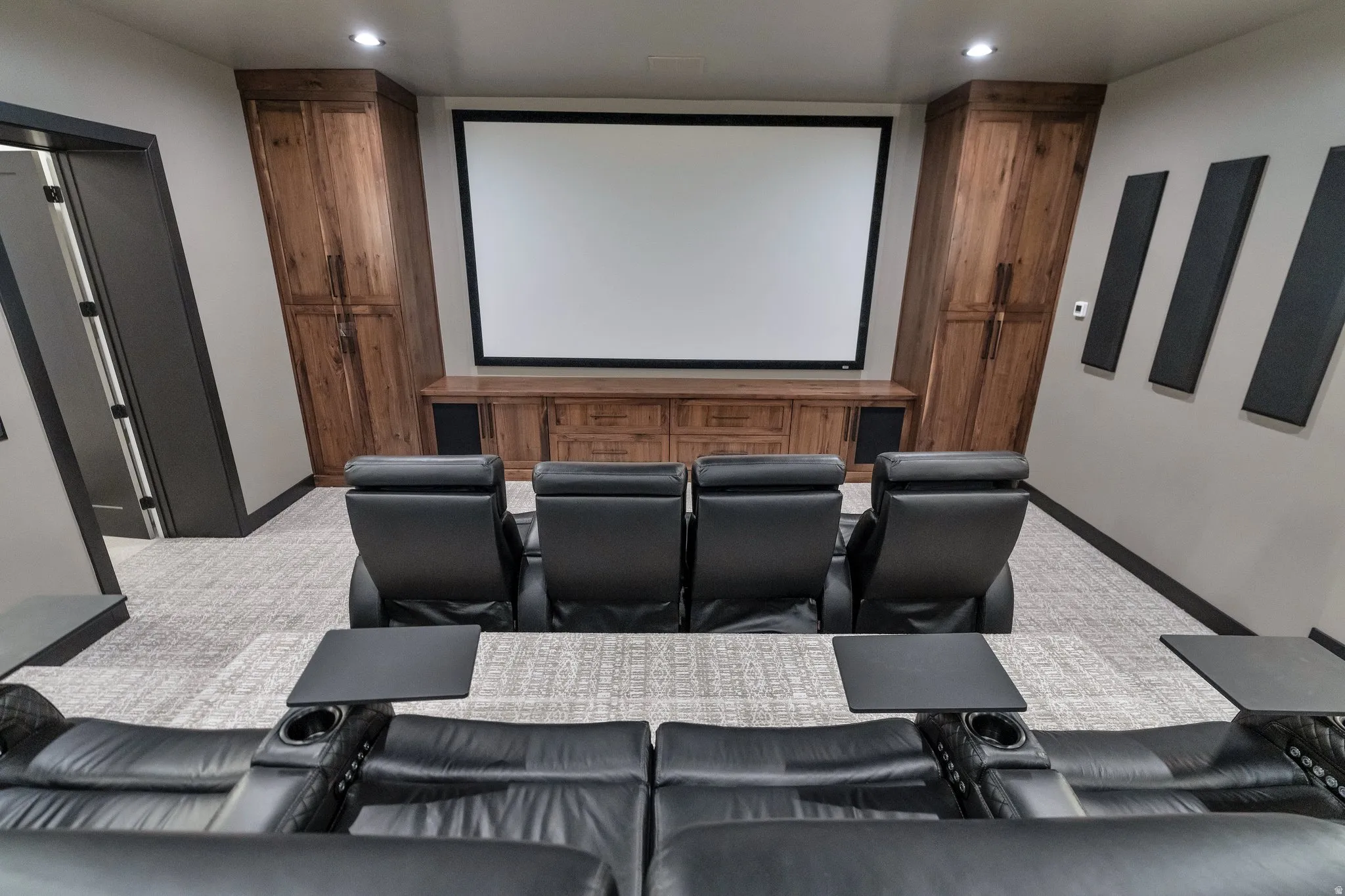 Cinema room featuring light colored carpet and baseboards