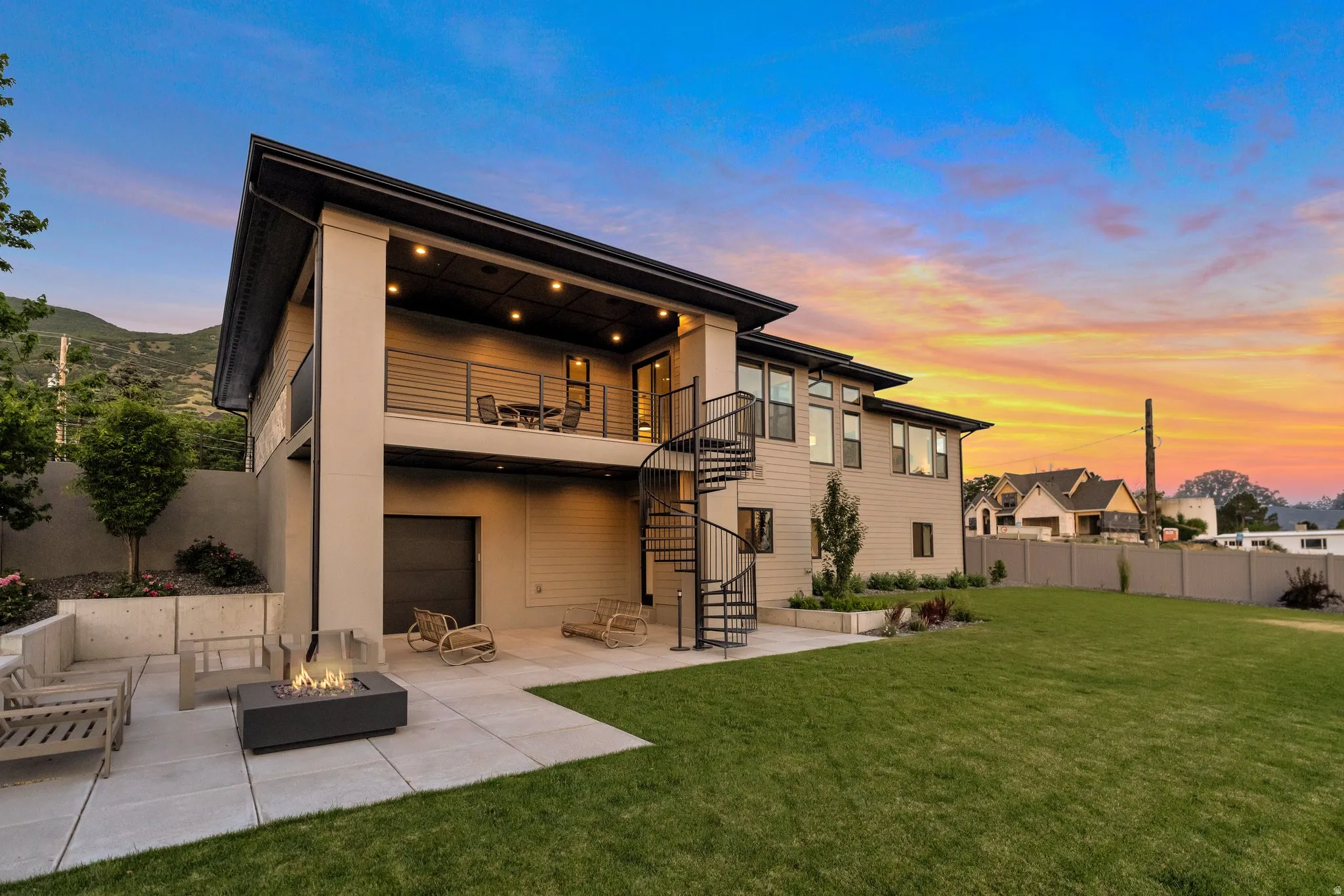 Rear view of property featuring a patio area, a balcony, and an outdoor fire pit