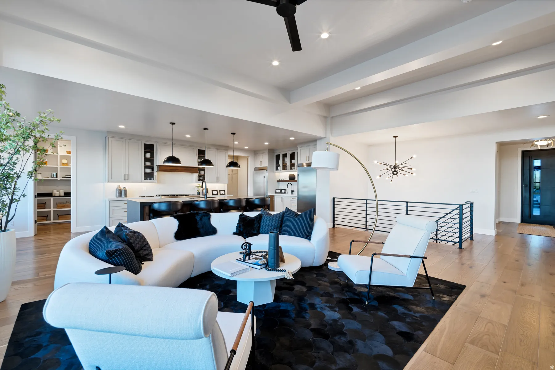 Living area featuring light wood-style floors, a ceiling fan, and hanging lights