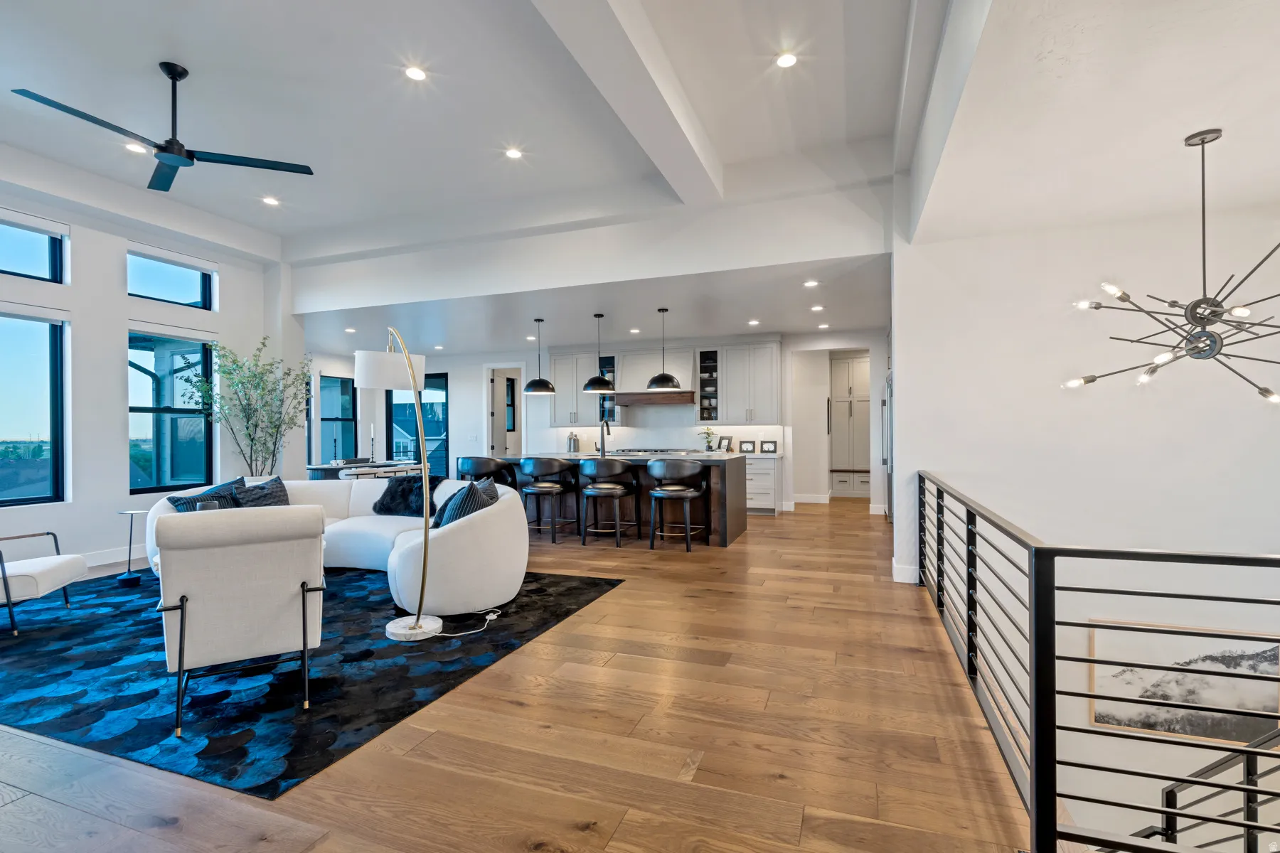 Living room featuring light wood-type flooring, hanging lights, and ceiling fan