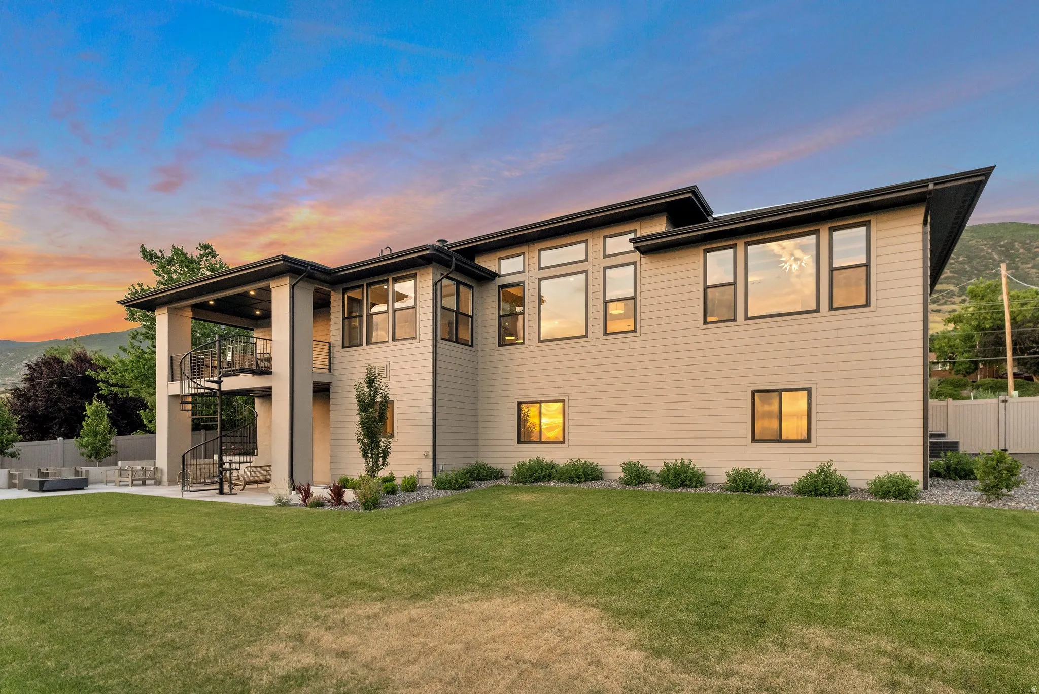 Back of property at dusk with a balcony, a patio area, and outdoor lounge area