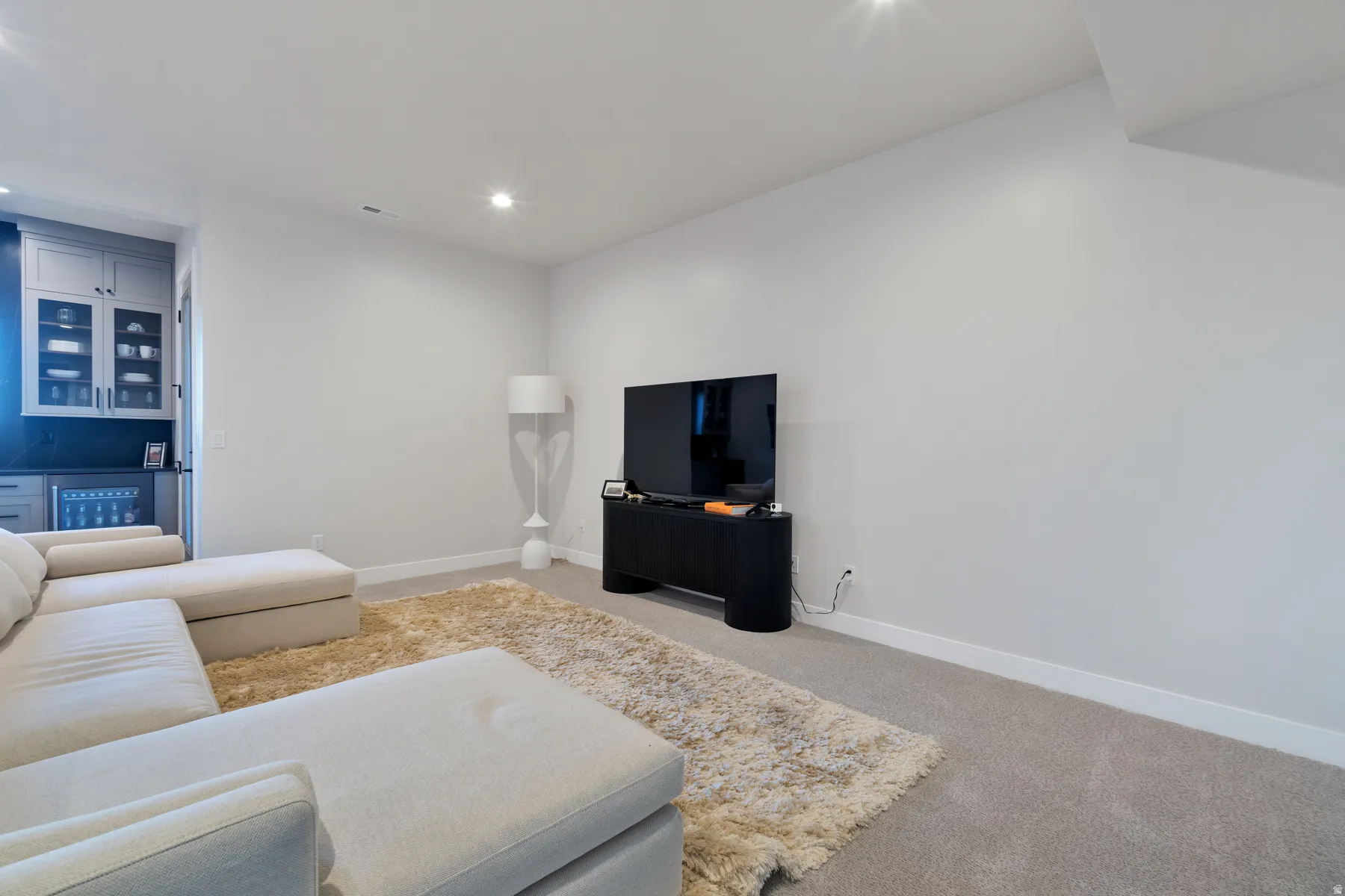 Living room with light colored carpet and recessed lighting