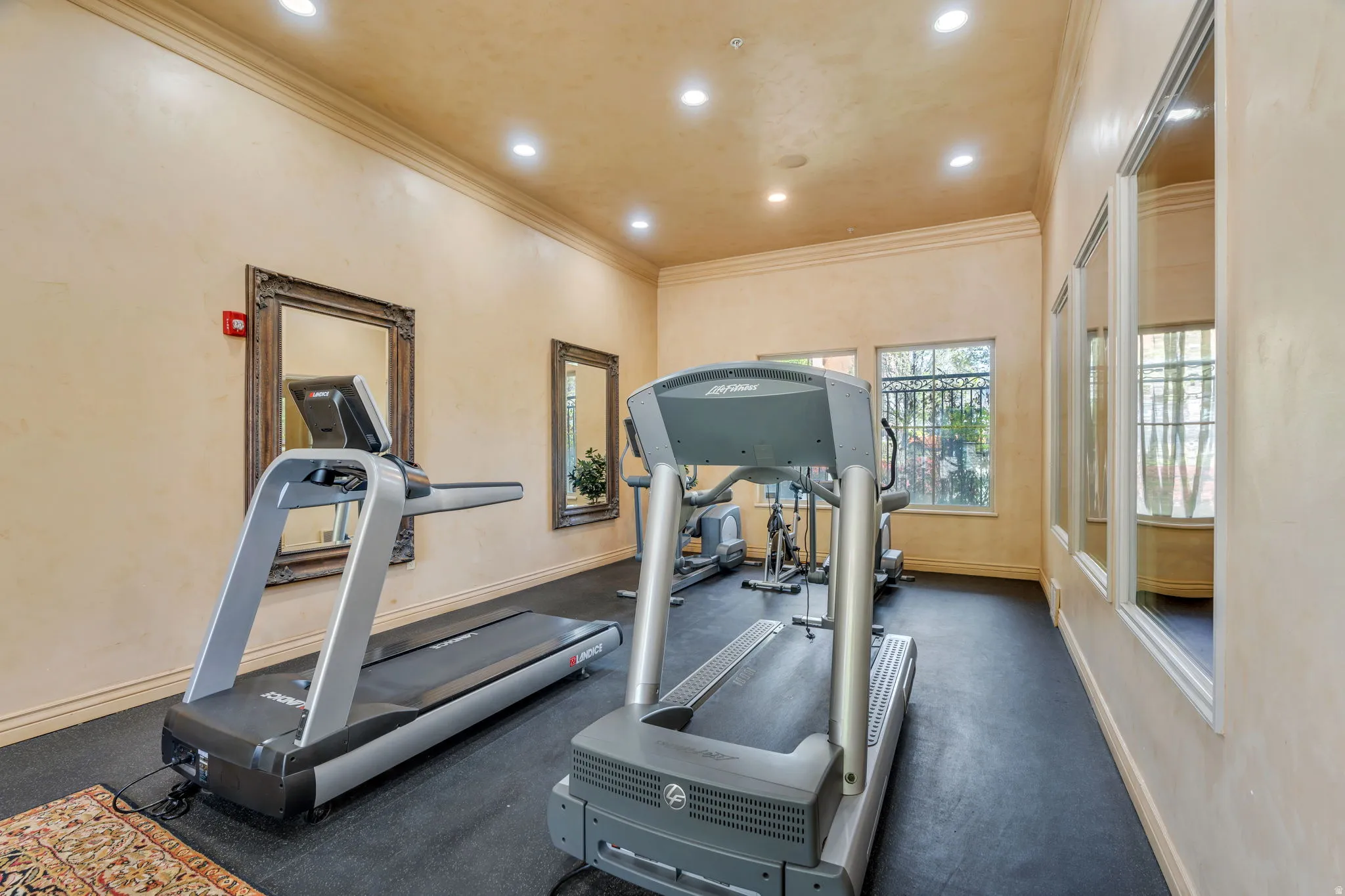 Workout area featuring ornamental molding and recessed lighting