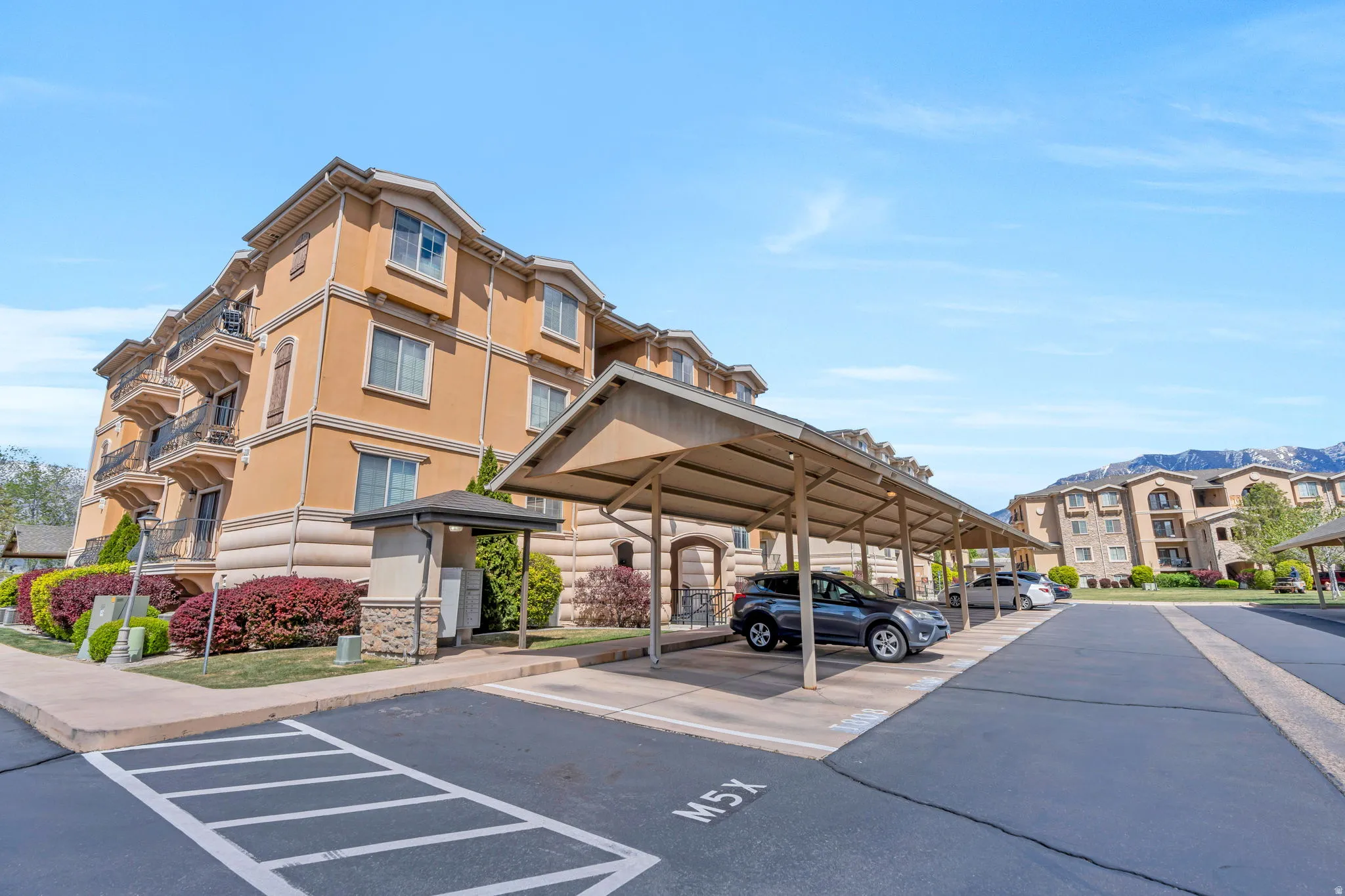 View of building exterior featuring covered parking