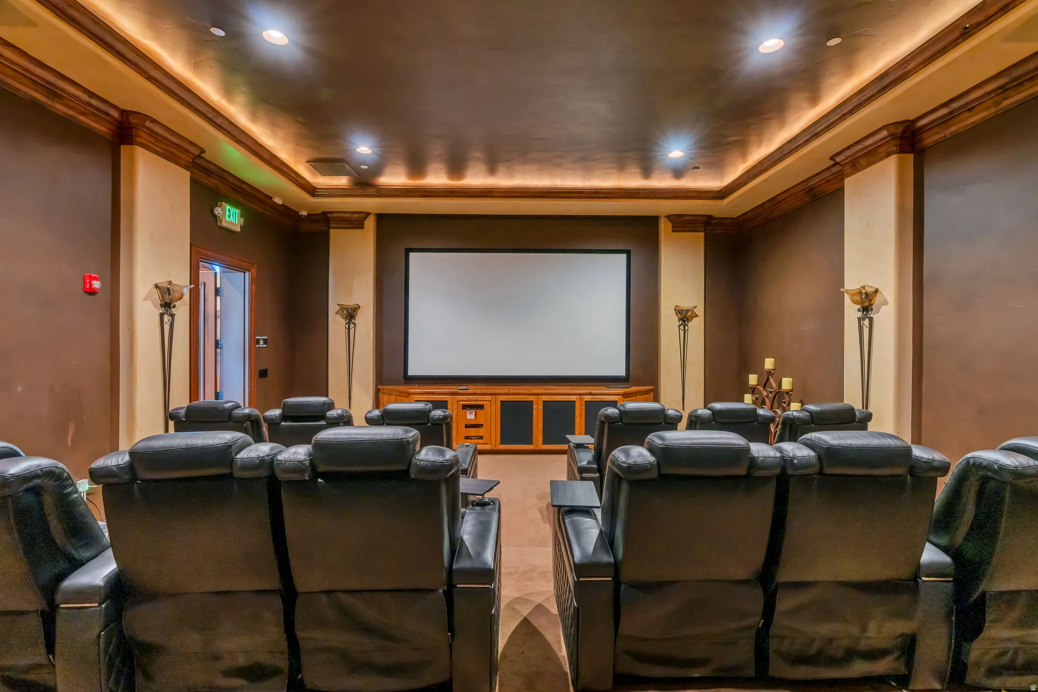 Cinema room with a raised ceiling, crown molding, and recessed lighting