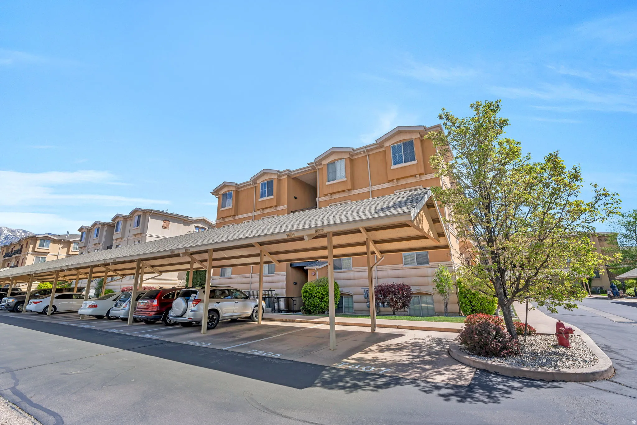 View of building exterior with covered parking and a residential view