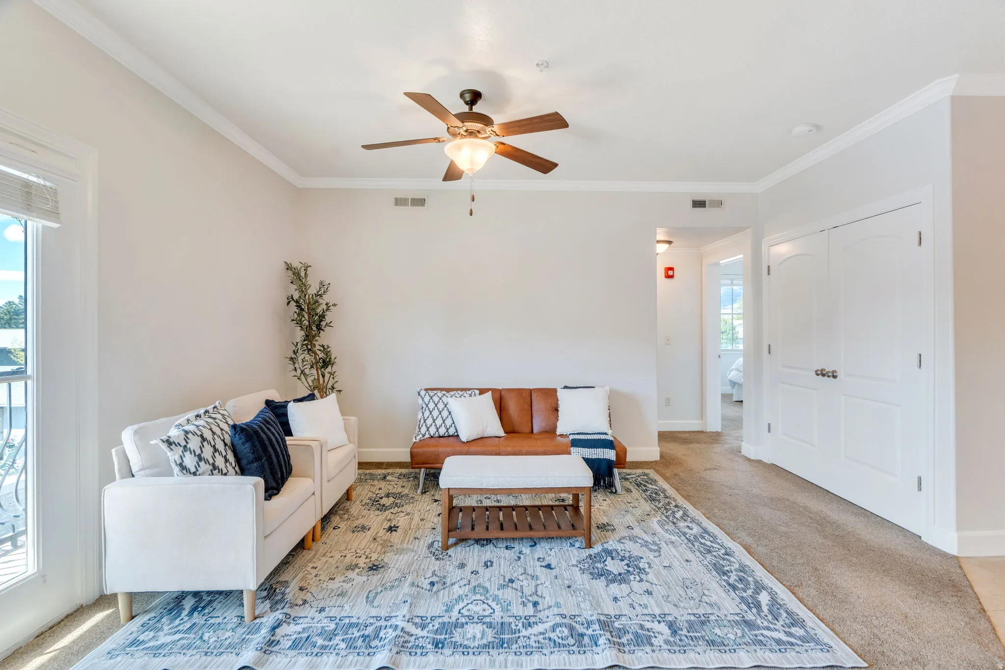 Sitting room featuring carpet, ceiling fan, and crown molding