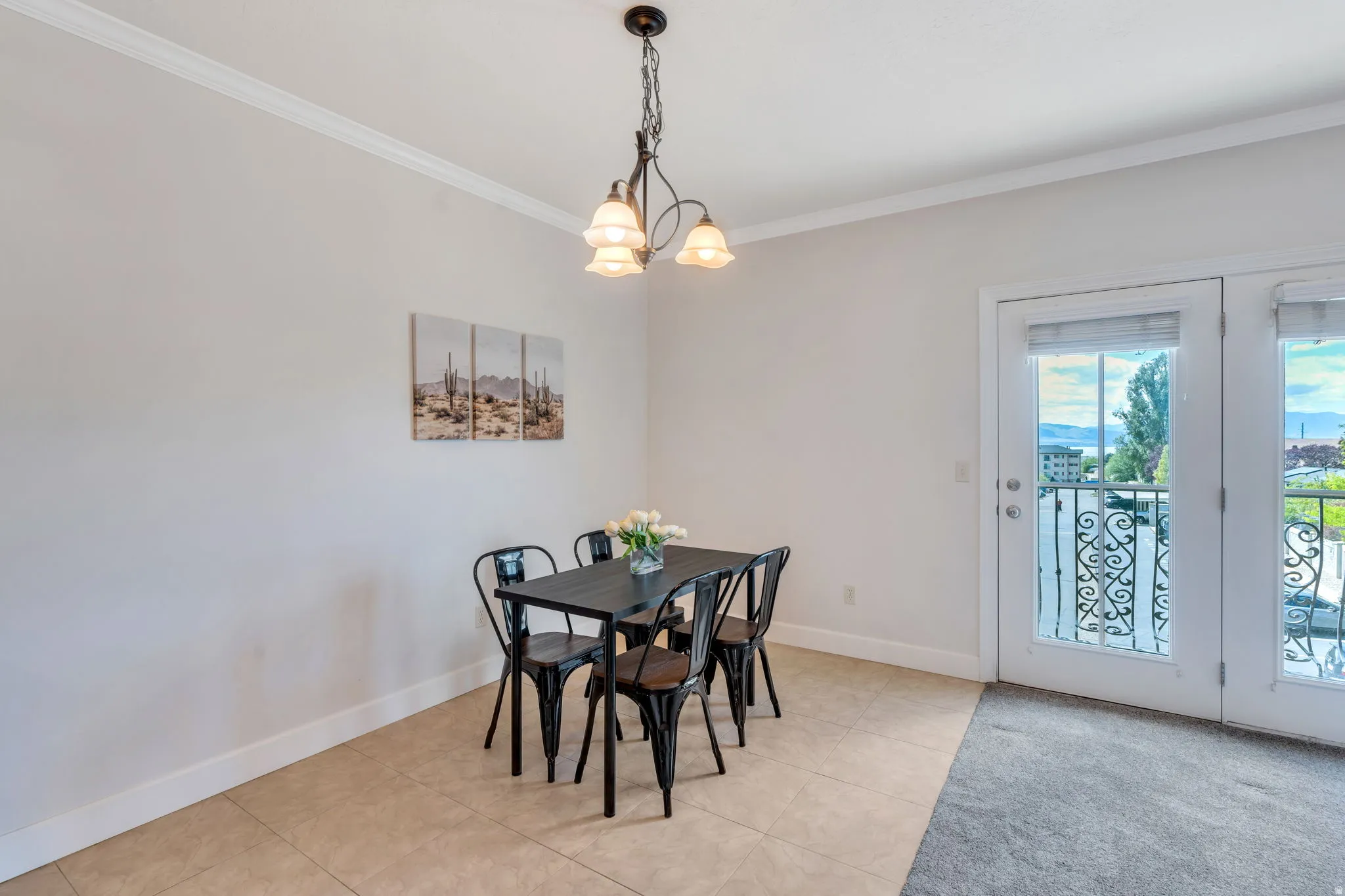 Dining room with crown molding, a chandelier, and light tile patterned flooring