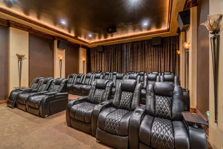 Carpeted home theater with a tray ceiling, crown molding, and recessed lighting