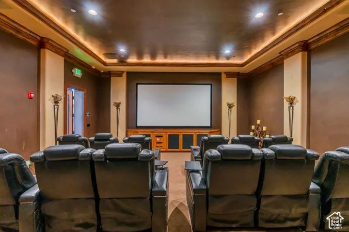Cinema room with a raised ceiling, crown molding, and recessed lighting